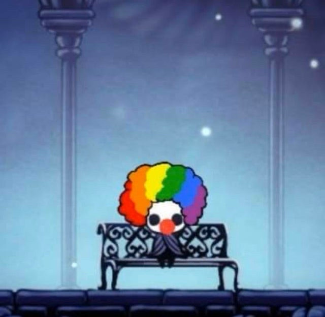 The Knight from Hollow Knight sitting on a bench wearing a clown wig and red nose